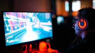 Gamer mit Headset spielt schwieriges PC-Spiel – Artikel über Spieldesign und Schwierigkeitsgrad