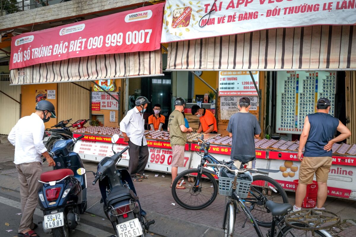 Người d&acirc;n mua v&eacute; xổ số từ người b&aacute;n v&eacute; dạo tr&ecirc;n vỉa h&egrave; Việt Nam