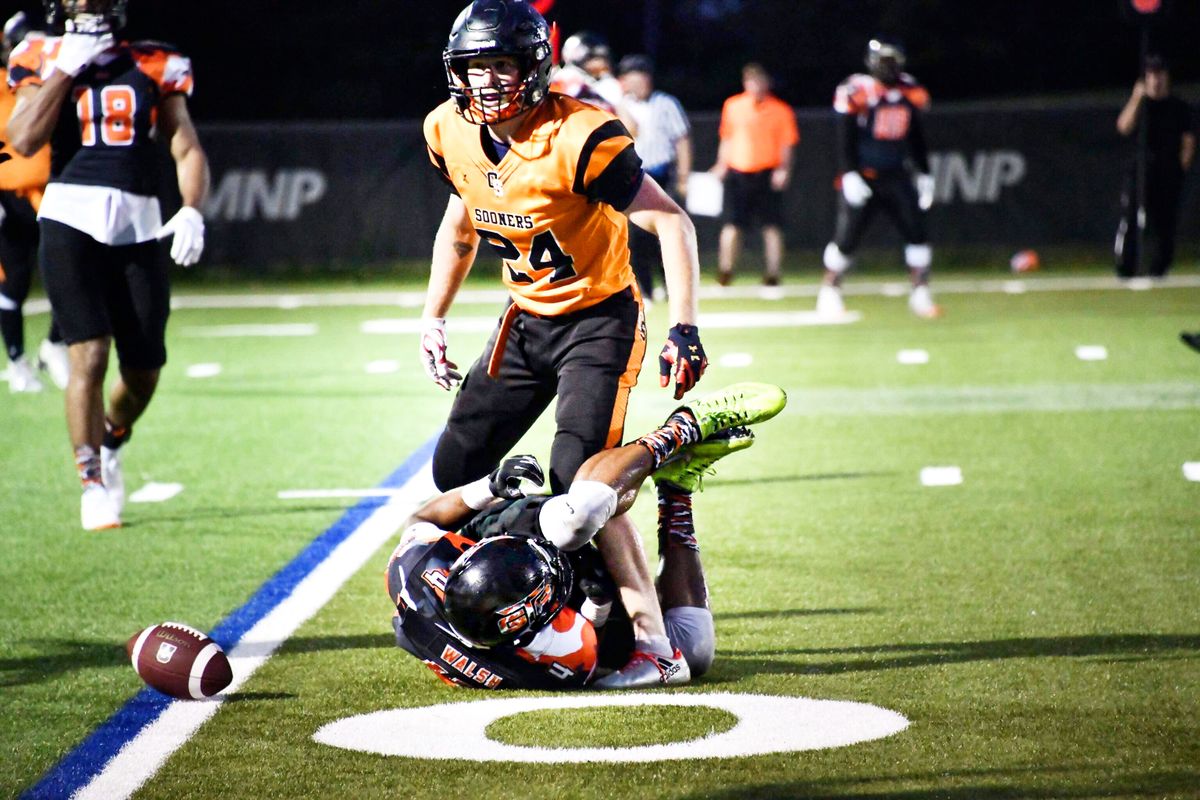 American football players making a tackle during a night game