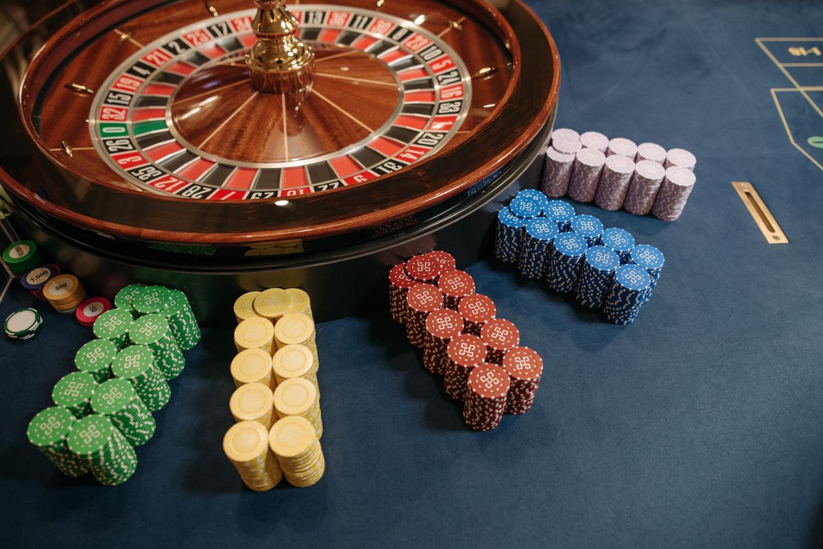 Stacked casino chips next to a roulette wheel on a casino table