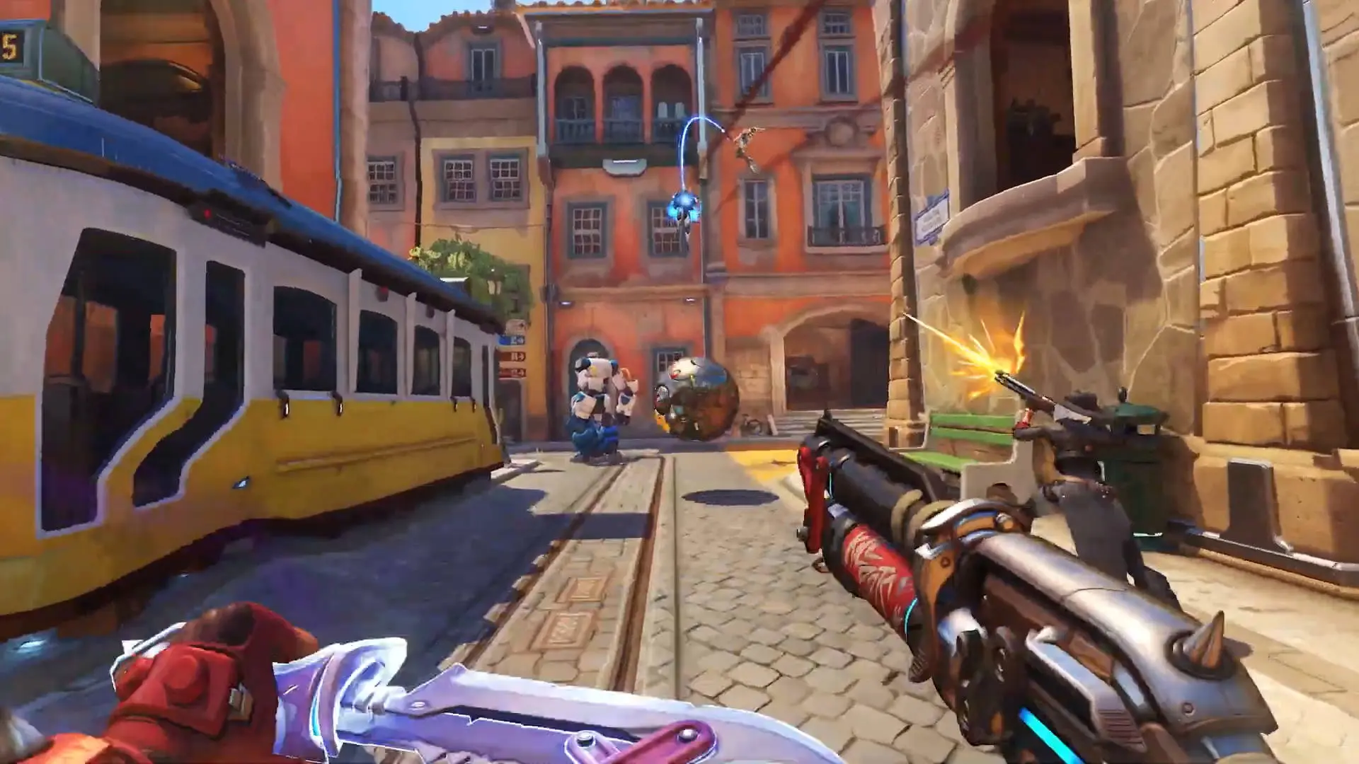 First-person view of Overwatch 2 gameplay featuring Junker Queen in a city street environment.