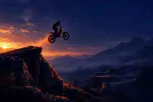 A motocross rider launches over an obstacle course under deep navy and orange lighting