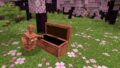 A Copper Golem standing next to a chest, soon to be introduced in the Minecraft Copper Update.