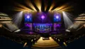 Dramatic esports arena stage with purple and gold lighting, gaming chairs, and championship setup