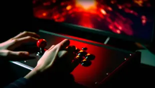 Fight stick controller in red emergency lighting showing Tekken 8 community crisis and emergency patch response